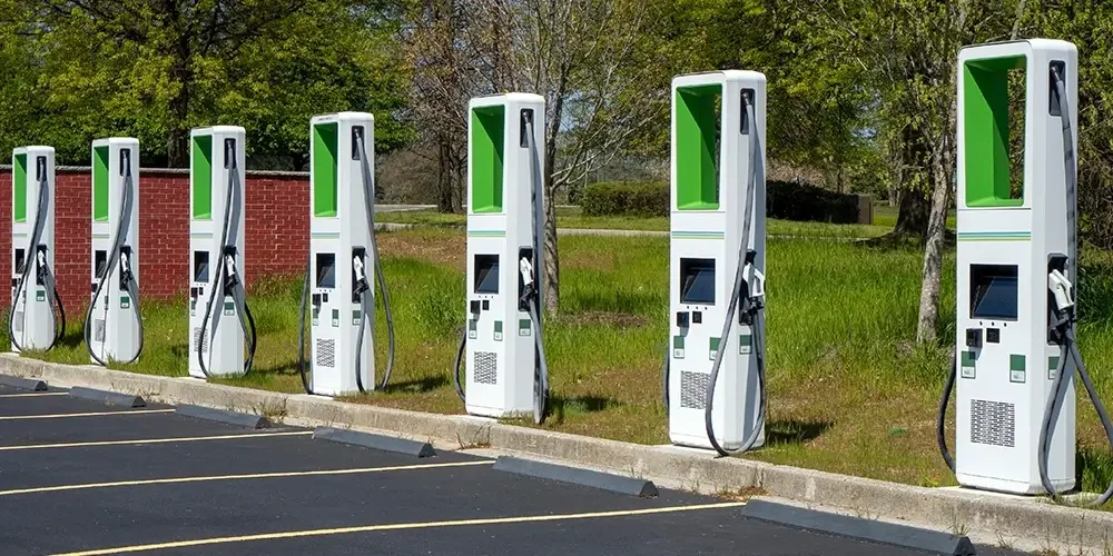 A row of electric vehicle charging stations in an outdoor parking lot